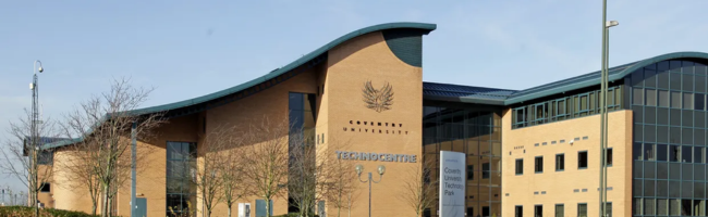 Daytime external view of the front of CoventryConferences TechnoCentre with clear blue sky